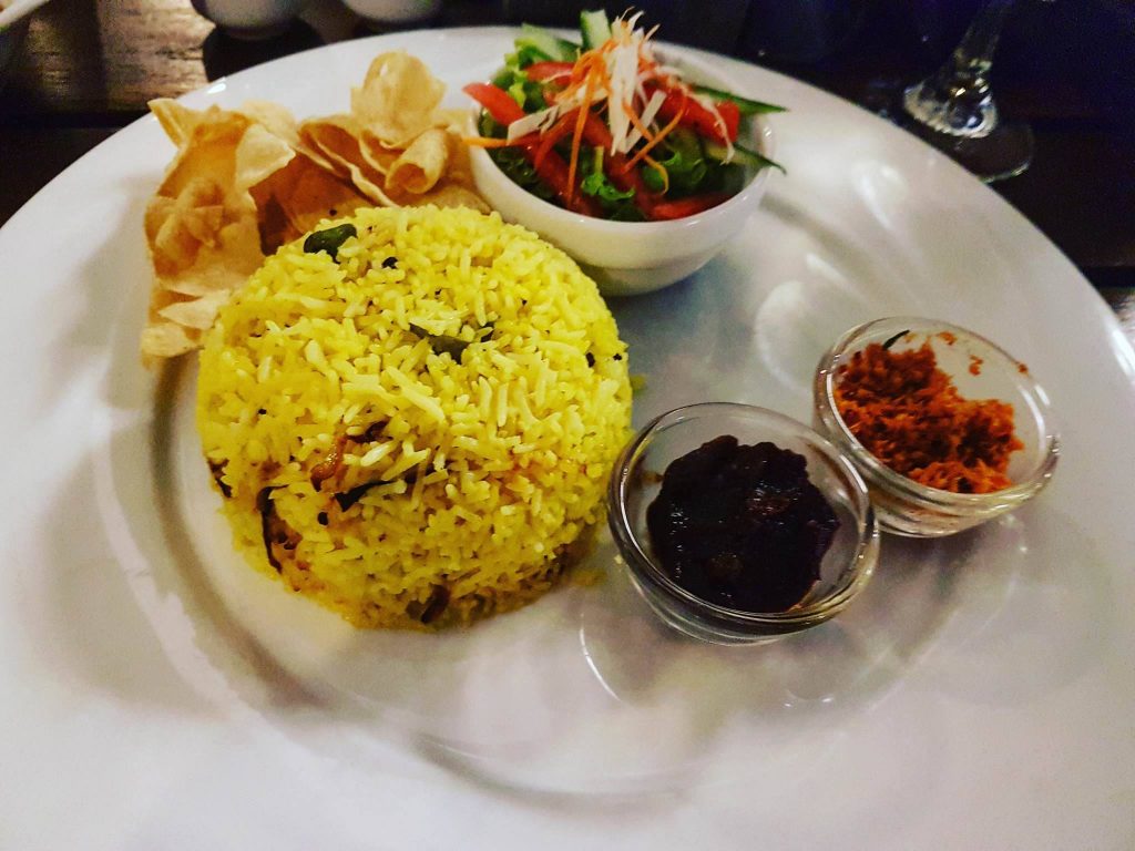 Curry Fish z szafranowym ryżem, pomidorowym chutney, chili, sałatką i chipsami papadam w restauracji SUGAR w Colombo